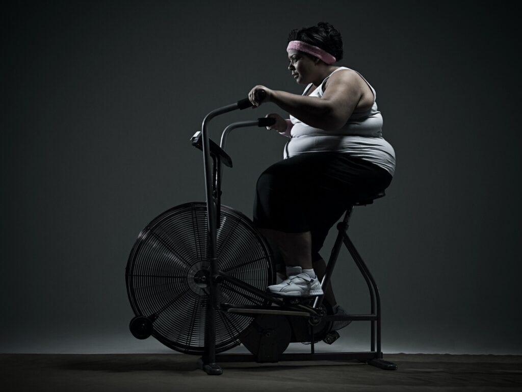 Overweight woman on exercise bike